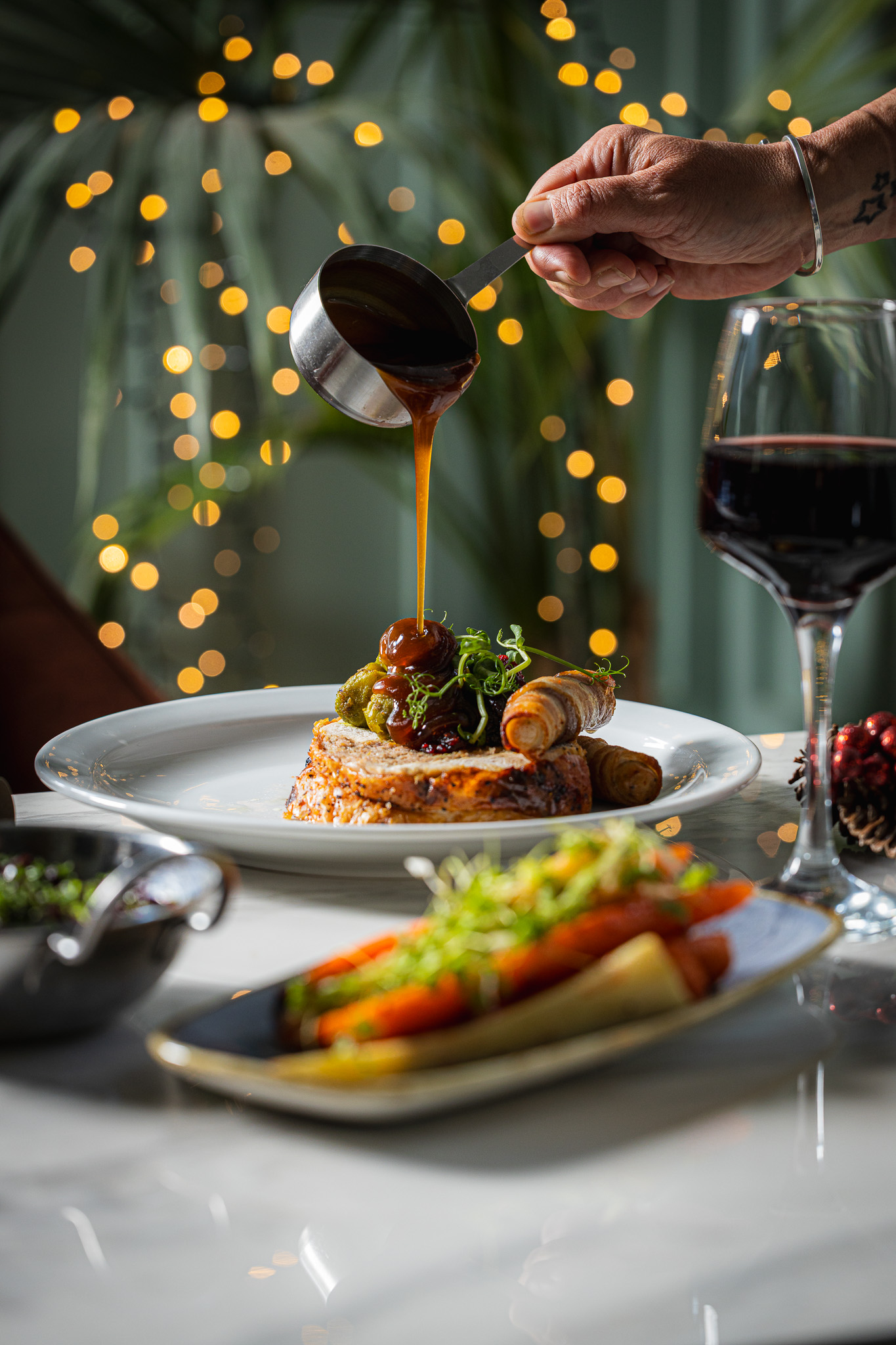 Christmas turkey dinner with gravy being poured and a glass of red wine at the orator